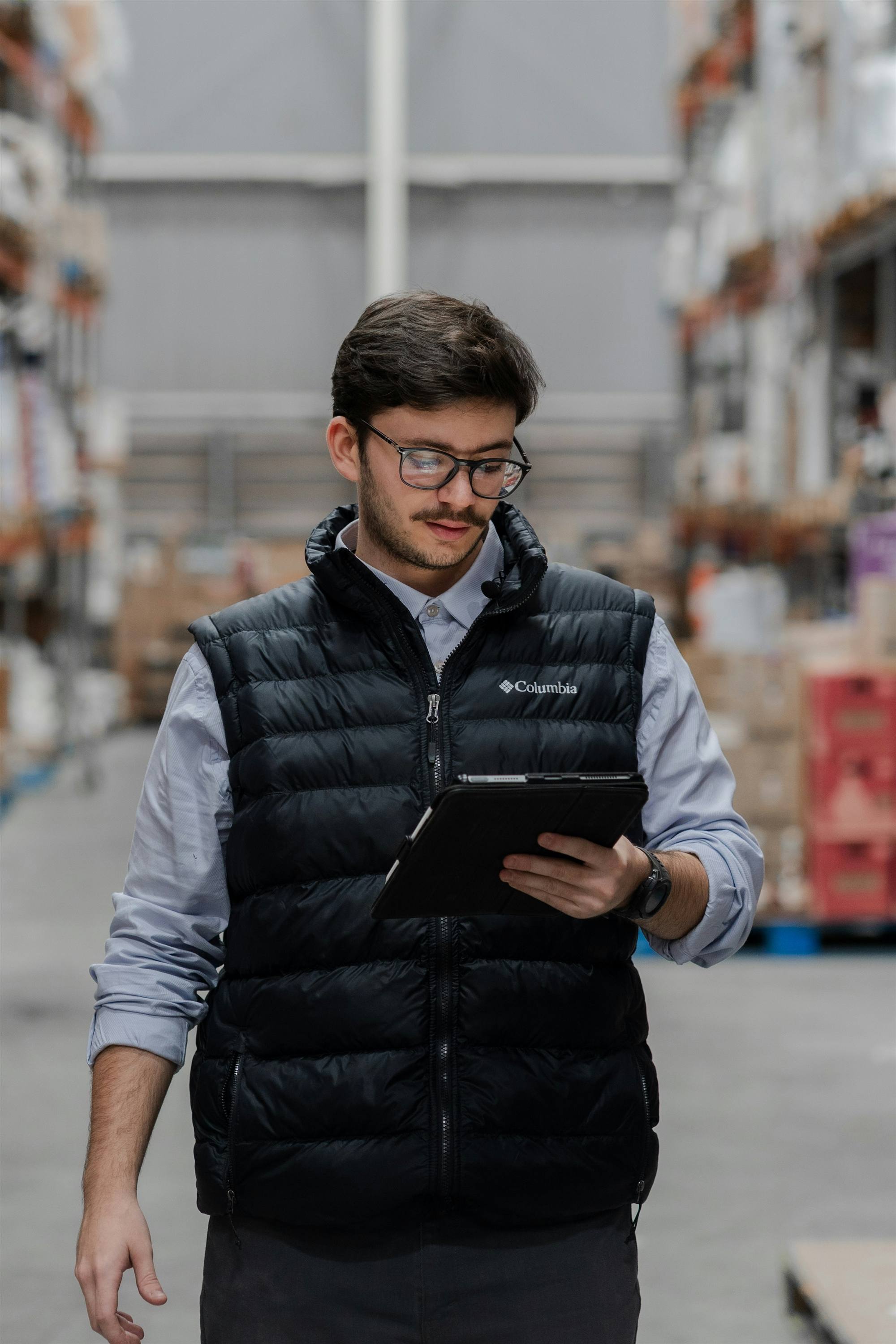 Operations lead reviewing data on a tablet in a warehouse